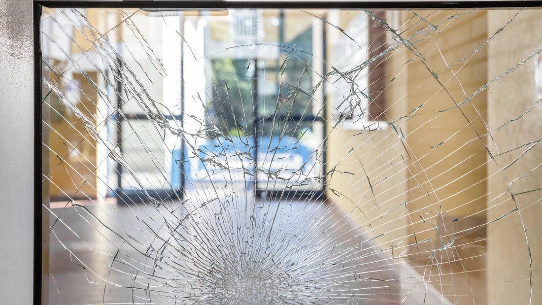 Shattered storefront glass held together by security film