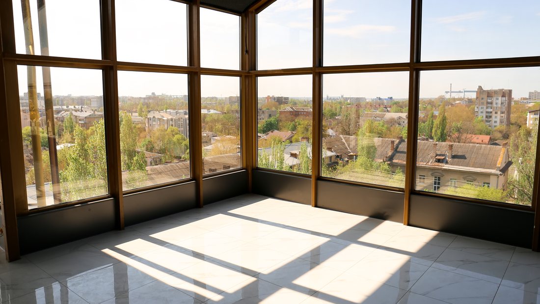 Sunlit room with floor-to-ceiling glass protected by clear UV film